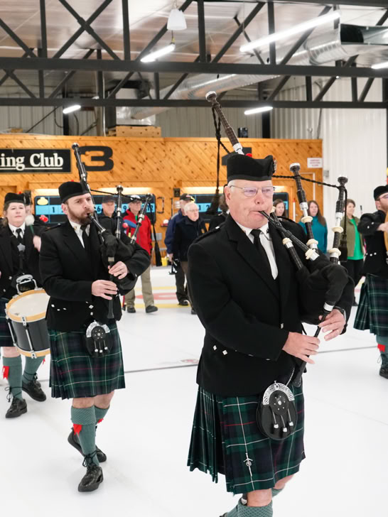Members of Fergus Pipe Band parading on Fergus Curling RInk ice.