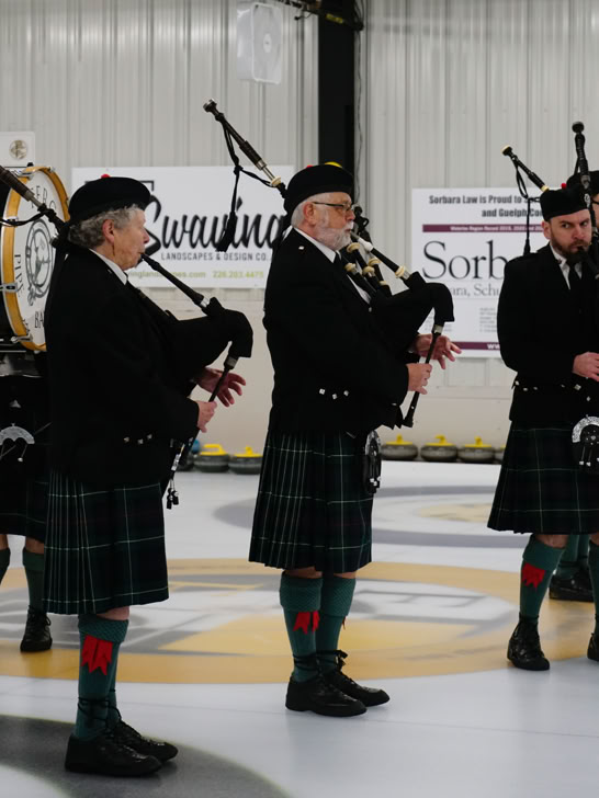 Members of the Fergus Pipe Band performing on the Fergus Curling Club ice.